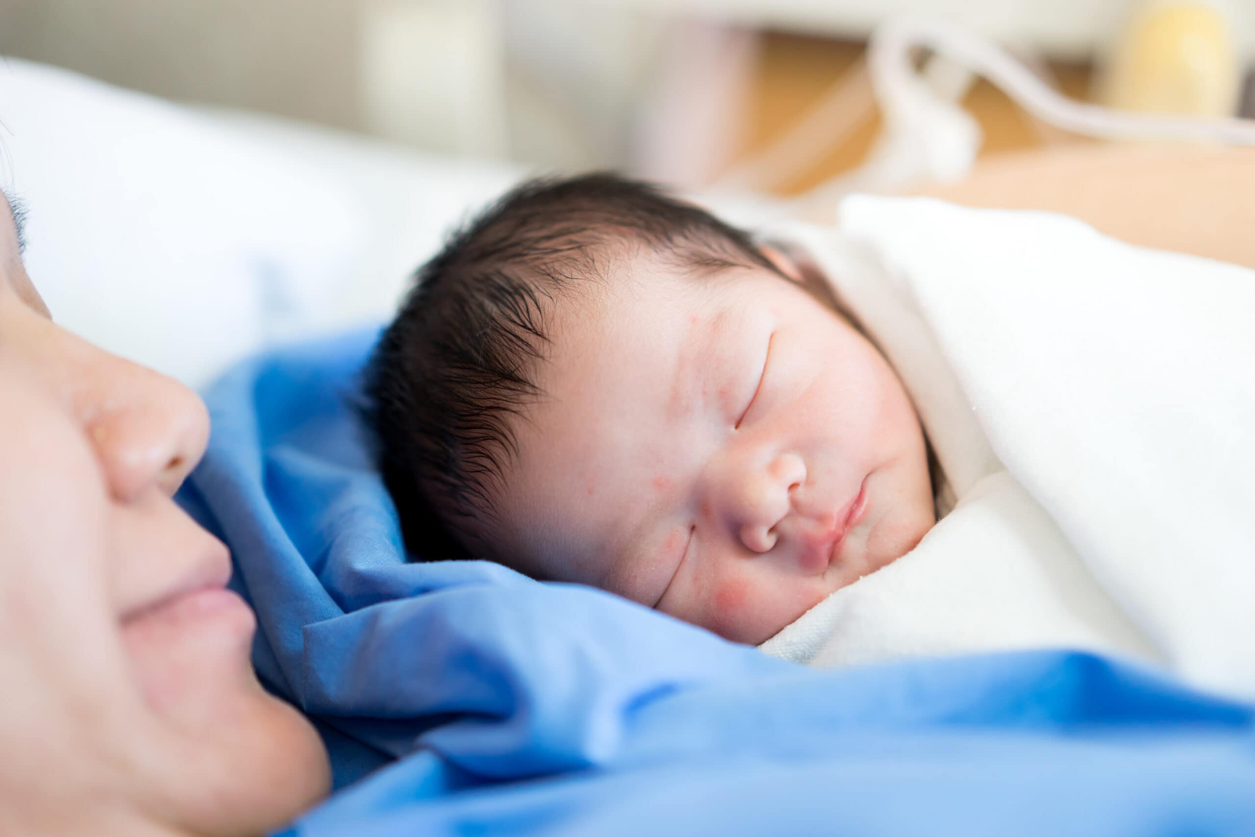 newborn baby laying on mother